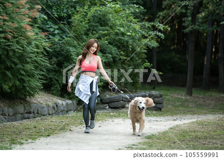 In the park, a lovely dog and a beautiful woman in sportswear are exercising together. In the park, a lovely dog and a beautiful woman in sportswear are exercising together. 105559991