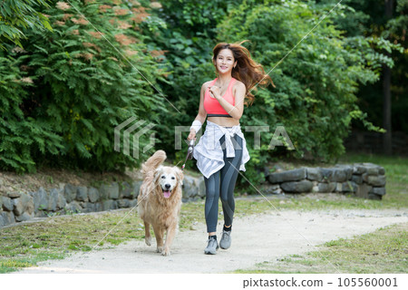 In the park, a lovely dog and a beautiful woman in sportswear are exercising together. 105560001