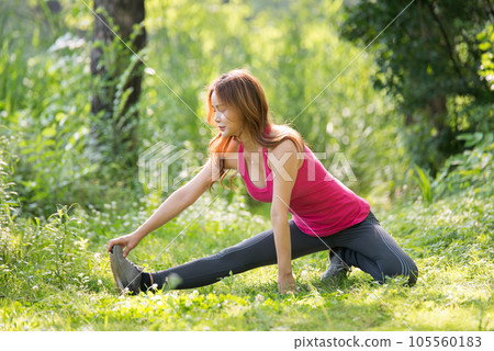 young woman doing yoga in the park 105560183