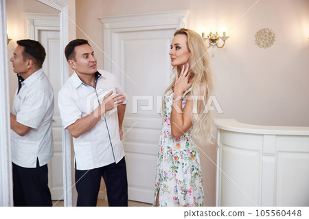 woman talking with doctor about face aesthetic treatment 105560448