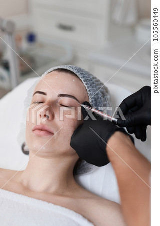 woman receives cosmetic botox injection in face. woman receives cosmetic botox injection in face. 105560449