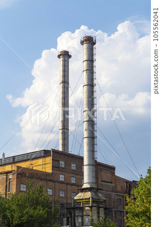 Industrial building with two tall chimneys background on blue sky 105562041