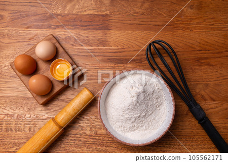 Flour on a wooden background with a rolling pin. The concept of cooking. High quality photo 105562171