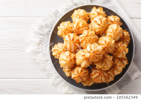 Natural baked coconut cookies or coconut macarons closeup on the plate. Horizontal top view Natural baked coconut cookies or coconut macarons closeup on the plate. Horizontal top view 105562349