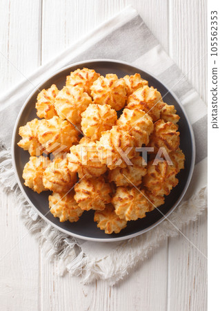 Fresh home baked coconut cookies closeup on the plate on the table. Vertical top view Fresh home baked coconut cookies closeup on the plate on the table. Vertical top view 105562353