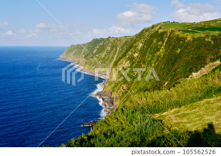 Green hills and Atlantic Ocean surf. Ponta Delgada island, Azores, Portugal. 105562526