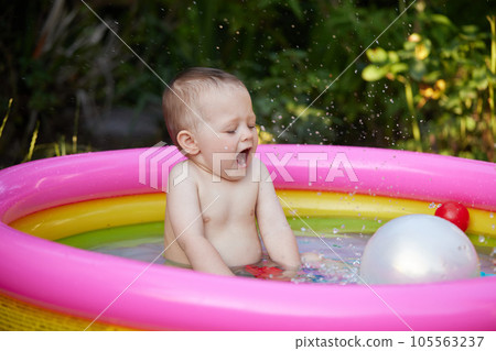 cute baby girl swimming in kid inflatable pool 105563237