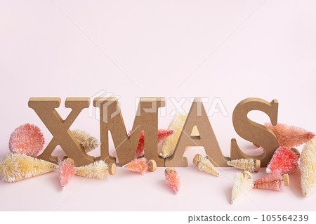 Christmastime still life. Artificial tiny Christmas trees and wooden XMAS word. 105564239