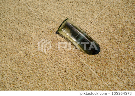 White glass bottle on the sandy beach in the sun, sea or ocean waste concept. Baltic Sea Latvia White glass bottle on the sandy beach in the sun, sea or ocean waste concept. Baltic Sea Latvia 105564573