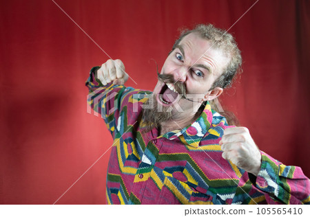 Hipster man with mustache threatening camera with his fist and shouting furious Hipster man with mustache threatening camera with his fist and shouting furious 105565410