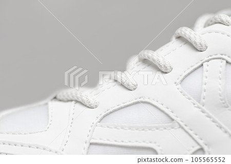 Part of a white sneaker with laces. A fragment of sports shoes 105565552
