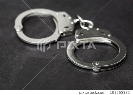 The metal handcuffs on black background. Handcuff or shackle. Police handcuffs The metal handcuffs on black background. Handcuff or shackle. Police handcuffs 105565583
