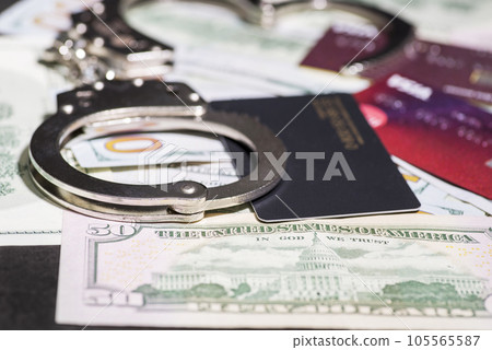 Steel handcuffs and credit cards lying on the background of American dollars. 105565587