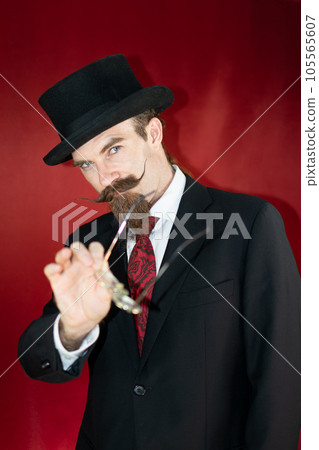 Vintage Caucasian Magician with top hat, glasses and mustache posing Vintage Caucasian Magician with top hat, glasses and mustache posing 105565607