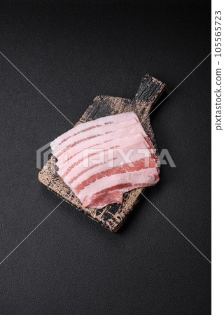 Fresh raw bacon cut into slices with salt, spices and herbs 105565723