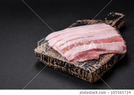 Fresh raw bacon cut into slices with salt, spices and herbs Fresh raw bacon cut into slices with salt, spices and herbs 105565724