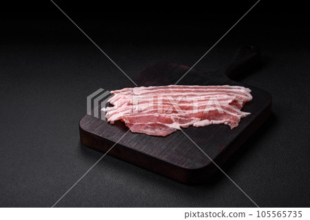 Fresh raw bacon cut into slices with salt, spices and herbs 105565735