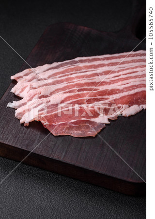 Fresh raw bacon cut into slices with salt, spices and herbs 105565740