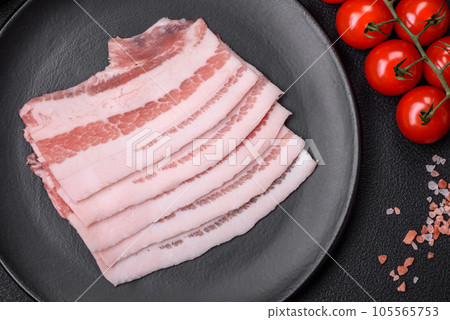 Fresh raw bacon cut into slices with salt, spices and herbs 105565753