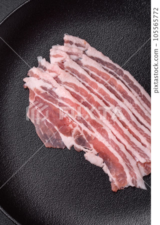 Fresh raw bacon cut into slices with salt, spices and herbs Fresh raw bacon cut into slices with salt, spices and herbs 105565772