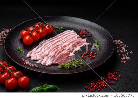 Fresh raw bacon cut into slices with salt, spices and herbs Fresh raw bacon cut into slices with salt, spices and herbs 105565773