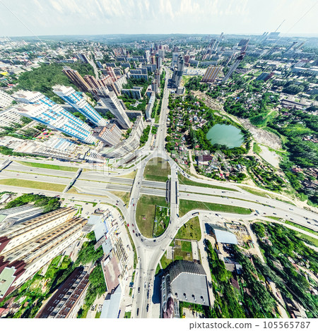 Aerial city view with crossroads and roads, houses, buildings, parks and parking lots. Sunny summer panoramic image 105565787