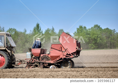 Farmer field with potato planter during spring planting. Farmer field with potato planter during spring planting. 105566117