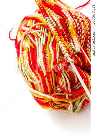 Knitting with multi colored yarn with orange, red, and yellow tones. Knitting with multi colored yarn with orange, red, and yellow tones. 105567111