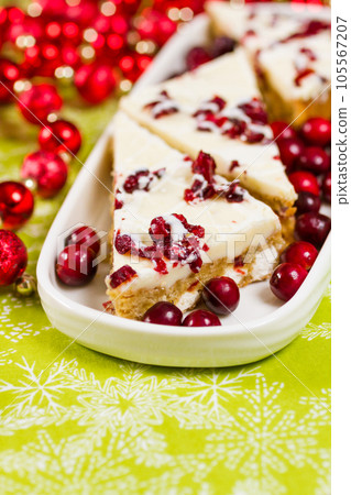Cranberry bliss bar made with chunks of white chocolate and dried cranberries, topped with sweet cream cheese icing. Cranberry bliss bar made with chunks of white chocolate and dried cranberries, topped with sweet cream cheese icing. 105567207