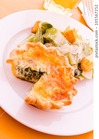 Individual spinach quiche served with salad. 105567252