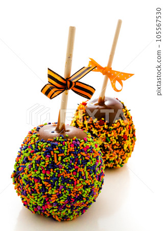 Hand dipped caramel apple covered with multi color sprinkles. 105567530