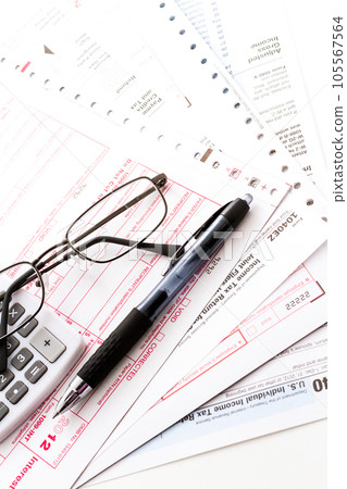 Calculating numbers for income tax return with pen and calculato 105567564