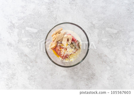 Flat lay. Mixing ingredients with hands in a glass mixing bowl to make meatloaf. Flat lay. Mixing ingredients with hands in a glass mixing bowl to make meatloaf. 105567603