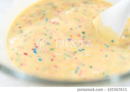 Close up view. Mixing ingredients in a glass mixing bowl to bake funfettti bundt cake. 105567615