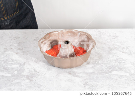Filling bundt cake pan with red, white, and blue cake dought to bake July 4th bundt cake with chocolate stars. 105567645