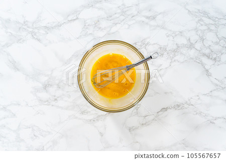 Flat lay. Mixing ingredients in a large glass mixing bowl to bake peppermint white chocolate cookies. Flat lay. Mixing ingredients in a large glass mixing bowl to bake peppermint white chocolate cookies. 105567657