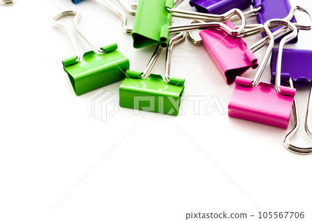 Multicolored paper clips in a pile on a white background. 105567706