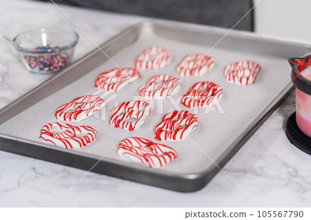 Dipping pretzels twists into melted chocolate to make red, white, and blue chocolate-covered pretzel twists. Dipping pretzels twists into melted chocolate to make red, white, and blue chocolate-covered pretzel twists. 105567790