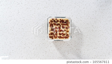 Flat lay. Cutting white chocolate cranberry pecan fudge into small pieces on a white cutting board. Flat lay. Cutting white chocolate cranberry pecan fudge into small pieces on a white cutting board. 105567811
