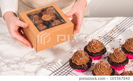 Step by step. Packaging chocolate cupcakes with chocolate ganache frosting into a paper cupcake box. Step by step. Packaging chocolate cupcakes with chocolate ganache frosting into a paper cupcake box. 105567840
