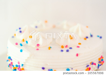 White little birthday cake with funfetti sprinkles on a white cake plate. White little birthday cake with funfetti sprinkles on a white cake plate. 105567898