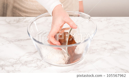 Step by step. Mixing ingredients in a glass mixing bowl to bake a chocolate cupcake. 105567962