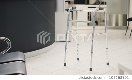 Diagnostic center with reception counter, walking frame placed in empty hospital lobby with registration front desk. Medical health care facility with chairs and consultation checkup. Diagnostic center with reception counter, walking frame placed in empty hospital lobby with registration front desk. Medical health care facility with chairs and consultation checkup. 105568591