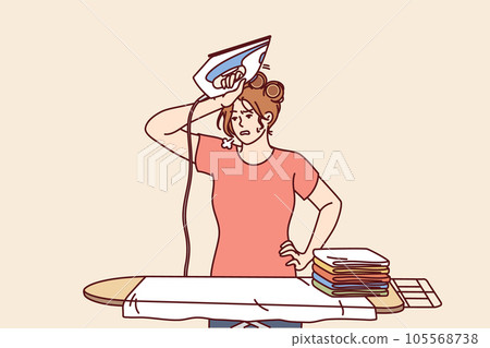 Tired woman housewife with iron wipes sweat from forehead standing near ironing board 105568738