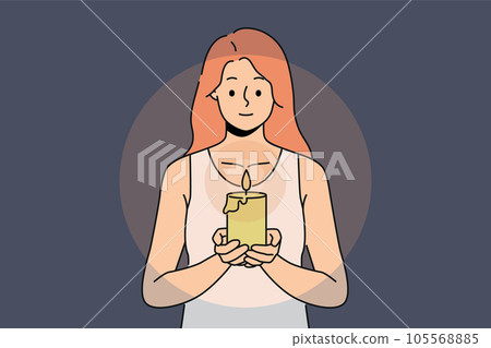 Woman with candle in hands looks at fire, performing religious ritual or seance. 105568885