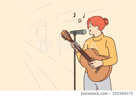 Woman street musician plays guitar and sings standing on sidewalk with microphone 105569173