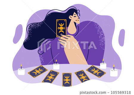 Woman predictor or fortune teller with tarot cards laid out on table with candles predicts future. 105569318