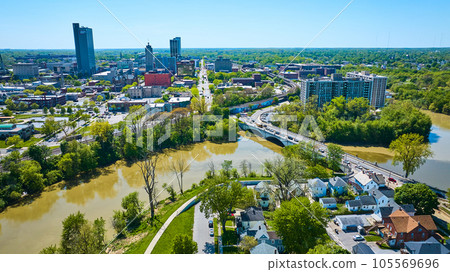 Cityscape landscape containing skyscrapers, churches, houses, apartments, winding river in summer Cityscape landscape containing skyscrapers, churches, houses, apartments, winding river in summer 105569696