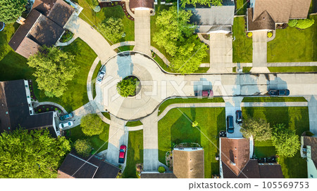 Patchy road in cul-de-sac with lower end houses downward rooftop aerial view 105569753
