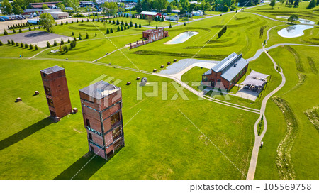 Aerial of lush green grass at Ariel Foundation Park and its factory building remains Aerial of lush green grass at Ariel Foundation Park and its factory building remains 105569758